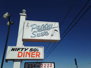 晴朗藍天下 Peggy Sue's Nifty 50's Diner 的復古餐館招牌。 — 50年代美式餐廳 壁紙