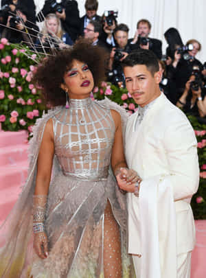 Priyanka Chopra 和 Nick Jonas 在粉紅色地毯上的華麗活動中一起擺姿勢。 — 女神卡卡 壁紙