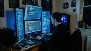 編碼員深夜工作，多個顯示器顯示程式碼。