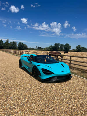 青綠色McLaren跑車停泊在牧場旁，馬匹在陽光藍天下吃草。 — Kindle 壁紙