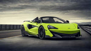 青檸綠色McLaren 570S Spider敞篷跑車在多雲的天空下的高速公路上。 — 5120x2880 壁紙
