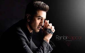 Ranbir Kapoor 身穿黑色西裝，手持手錶，旁邊有文字。 — 沙希德·卡普爾 壁紙