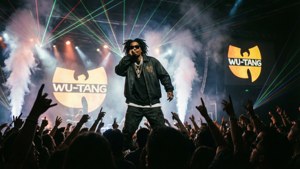 饒舌歌手在Wu-Tang Clan演唱會上表演，伴隨著雷射燈光和歡呼的人群。