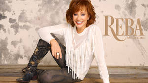 Reba McEntire 身穿白色流蘇毛衣和鉚釘靴，在木樓梯上微笑。 — 音樂 壁紙