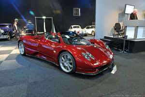 紅色Pagani Zonda跑車在車展上展示，後面有經典汽車。 — 3:2 壁紙