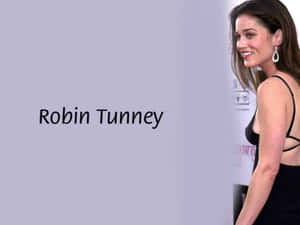 Robin Tunney 身穿黑色連衣裙，在薰衣草背景上微笑看向鏡頭，帶有名字文字。 — 羅賓漢 壁紙