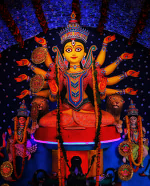 色彩繽紛的多臂杜爾迦雕像，基座兩側有獅子。 — Maa Durga 壁紙
