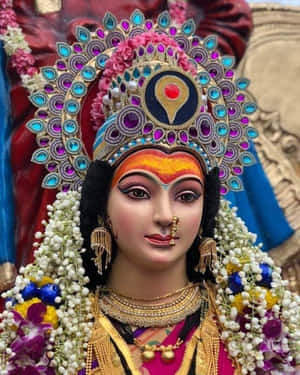一尊裝飾著花環和黃金首飾的印度教女神雕像。 — Maa Durga 壁紙