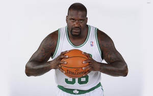 Shaquille O'Neal 身穿塞爾提克球衣在攝影棚肖像中握著籃球。 — 波士頓塞爾提克 壁紙