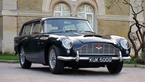 黑色經典Aston Martin DB6 Shooting Brake停放在石建築前。 — 奧斯頓馬丁 壁紙