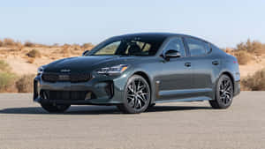 灰色Kia Stinger轎車停在沙漠公路，日落時分。 — 起亞 壁紙