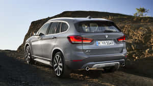銀色BMW X1 SUV停泊在岩石山坡附近的碎石上。 — Mercedes Benz C300 壁紙