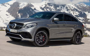 銀色Mercedes-AMG GLE63 S Coupe停在山路上，背景是白雪覆蓋的山峰。 — Steam Deck OLED 壁紙