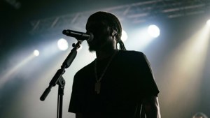 歌手在煙霧中的明亮聚光燈下在舞台上表演。