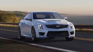 銀色Cadillac ATS-V轎跑車在日落時分行駛在海岸高速公路上。 — 凱迪拉克 壁紙