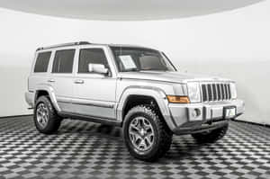 銀色Jeep Commander SUV在白色工作室的棋盤格地板上。 — MacBook Air M3 壁紙