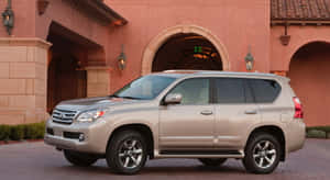 銀色Lexus GX SUV停放在帶有拱門的西班牙風格建築前。 — 凌志 壁紙
