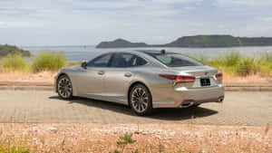 銀色Lexus轎車停泊在海濱，背景有島嶼。 — Pro Display XDR 壁紙