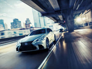 銀色Lexus房車在都市高架橋下疾馳，背景模糊動態。 — 凌志 壁紙