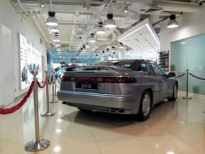 銀色SVX汽車在明亮的展廳中展示在紅色繩索屏障後面。 — 昴 壁紙