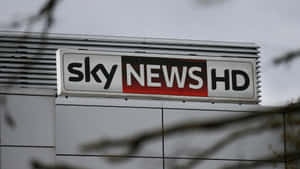 建築物上的 Sky News HD 標誌，前面有樹枝。 — 桌面 壁紙