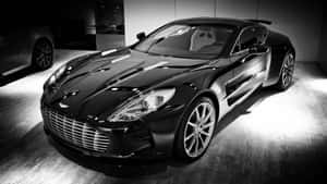 黑色Aston Martin跑車在昏暗的展示間中，聚光燈照射。 — 奧斯頓馬丁 壁紙
