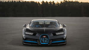 日落時分賽道上的黑色Bugatti Chiron，帶有藍色飾邊。 — 布加迪 GIF 壁紙
