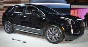 黑色 Cadillac XT5 SUV 在車展上展示，具有拋光表面和合金輪圈。 — 凱迪拉克 壁紙