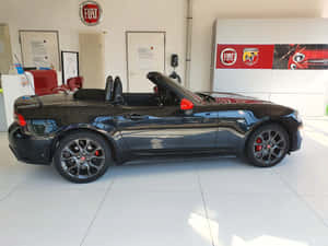 經銷商處帶有紅色細節的黑色Fiat 124 Spider敞篷車。 — 飛雅特 壁紙