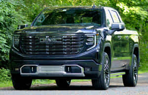 黑色GMC Sierra Denali皮卡車停在森林中的碎石路上。 — Steam Deck OLED 壁紙