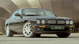 黑色Jaguar XJR 100豪華轎車停在現代建築附近。 — 美洲豹汽車 壁紙