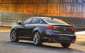 日落時分，黑色Kia Cadenza轎車停放在金色城市高架橋下。 — MacBook Pro 13 壁紙