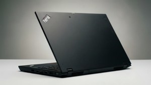 黑色 Lenovo ThinkPad 筆記型電腦在白色桌上打開，灰色背景