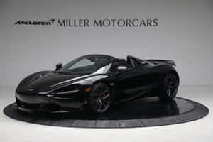 黑色McLaren 720S Spider敞篷跑車在展示間中展示。 — MacBook 壁紙