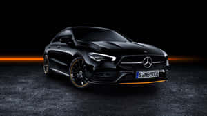 黑色梅賽德斯-AMG CLA45 S 在深色工作室環境中帶有橙色飾邊。 — Mercedes-Benz 壁紙