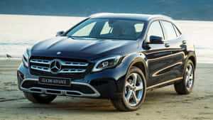 黑色 Mercedes-Benz GLA 200 Advance SUV 停泊在海邊沙灘上。 — 豪華車 壁紙