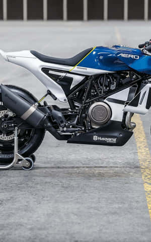 時尚的藍白色 Husqvarna 摩托車停放在混凝土上。 — Nubia Flip2 壁紙