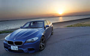 日落時藍色BMW M5停在水邊 — Steam Deck 壁紙