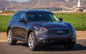 深紫色 Infiniti SUV 停在靠近綠色田野和山丘的道路上。 — MacBook Pro 13 壁紙