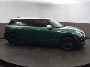 工作室中旋轉展示平台上的綠色MINI Countryman SUV。 — 4:3 壁紙