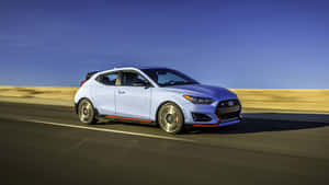 淺藍色Hyundai Veloster N在日落時分於沙漠高速公路上奔馳。 — 酷車 壁紙