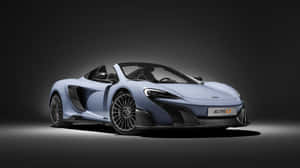 淺藍色McLaren 675LT跑車，帶有黑色細節，在黑暗的攝影棚環境中。 — 2560x1440 壁紙