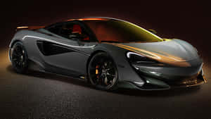 在黑暗的工作室環境中，帶有金色亮點的時尚灰色McLaren跑車。 — 酷炫F1 壁紙