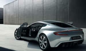 銀色Aston Martin跑車打開鷗翼車門停泊在混凝土上。 — 奧斯頓馬丁 壁紙