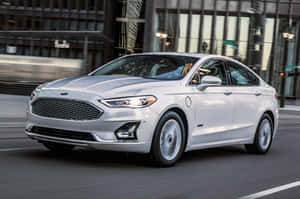 銀色Ford Fusion Hybrid在模糊建築的城市街道上行駛。 — 福特 壁紙