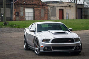 銀色福特野馬Shelby GT500停泊在磚砌建築附近的碎石上。 — 野馬GIF 壁紙