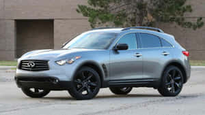 銀色Infiniti SUV，配備黑色輪圈，停在磚造建築附近的瀝青路面上。 — 豪華車 壁紙