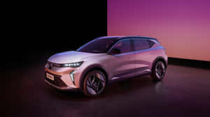 一輛現代的銀色電動SUV，在紫色和橙色的工作室環境中帶有發光的車頭燈。 — 雷諾 壁紙