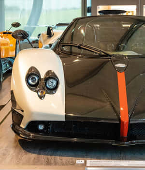 白色和碳纖維帕加尼Zonda Cinque Roadster，帶有橙色條紋，在展廳中。 — 小米 Mix Flip 2 壁紙
