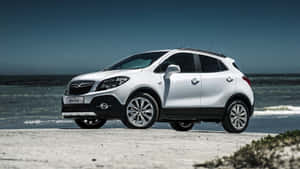 白色Opel Mokka SUV停泊在海灘上，有海浪和藍天。 — 歐寶 壁紙
